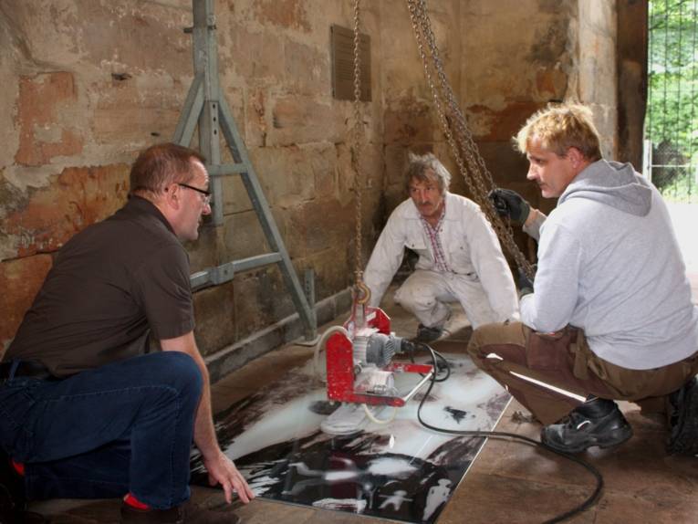 Künstler Ditmar Schädel fixiert sein Werk "… wir werden im Vertrauen auf Dich weiter unseren Weg gehen…“ im Boden der Aegidienkirche